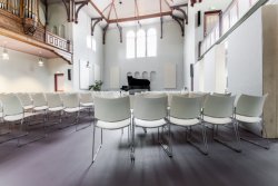 176104 Edesche Concertzaal vanaf achteruit gezien, mooie schaduwstrepen stoelen
